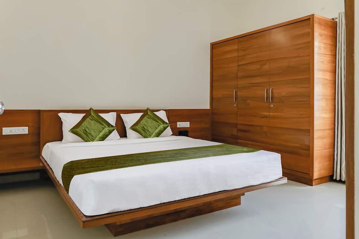 A modern bedroom with a wooden bed frame, a large wardrobe, and a bedside table.