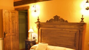 A bed with a wooden headboard, a nightstand with a lamp, and a door. - Rural apartment El Mirador de Cazanes for 2 people (Villaviciosa)