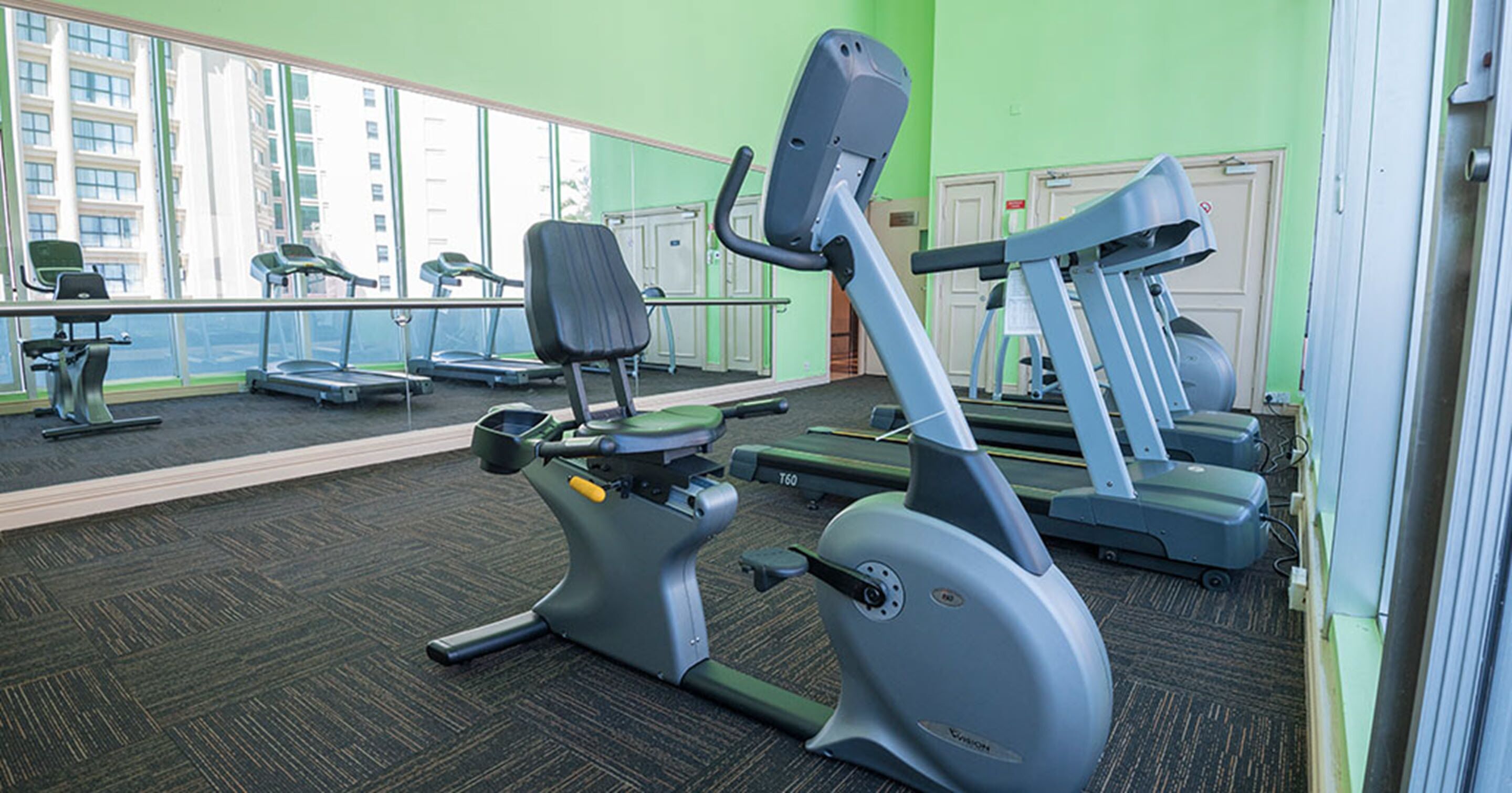 A gym with treadmills, stationary bikes, and exercise equipment.