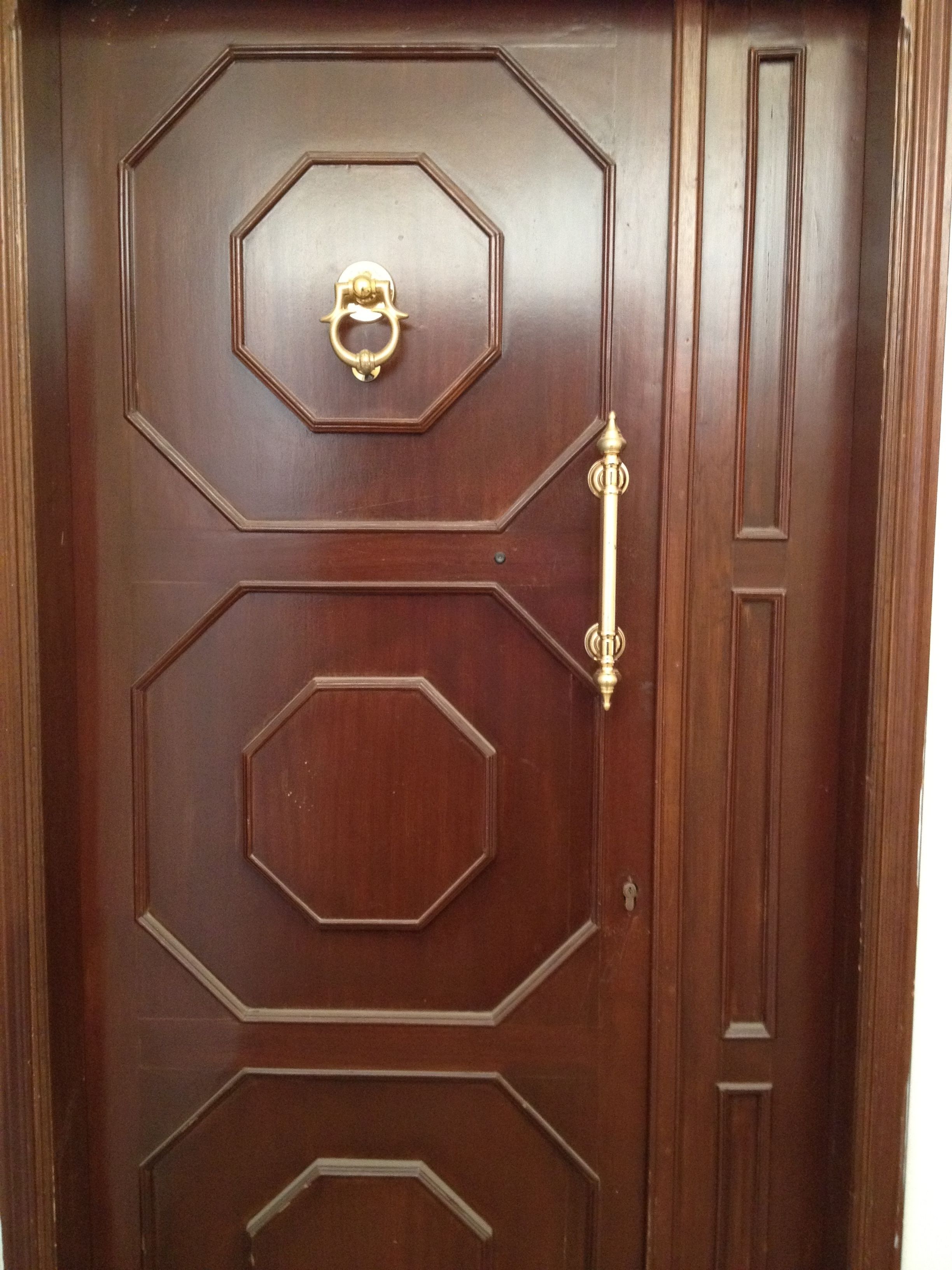 A wooden door with a brass handle and a keyhole.