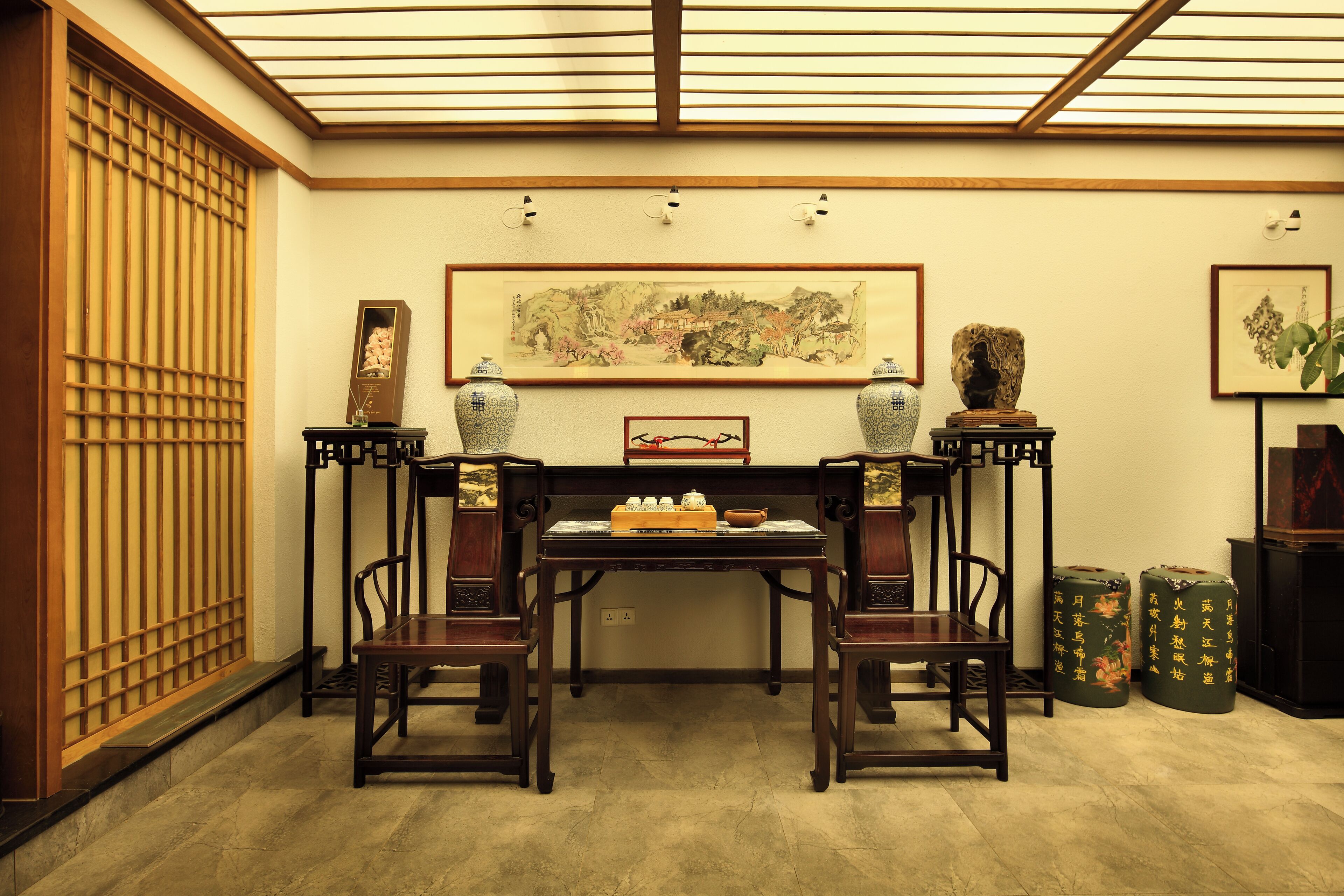 A traditional Japanese room with tatami flooring, a low table with a tea set, and two large vases on stands.