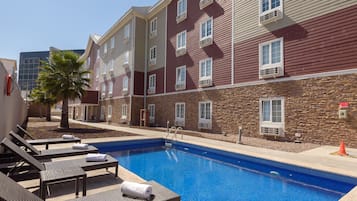 Alberca al aire libre, sombrillas en la alberca y camastros