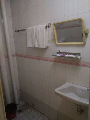 A bathroom with a sink, a mirror, and a towel rack. - Jade Hotel (Yangon)