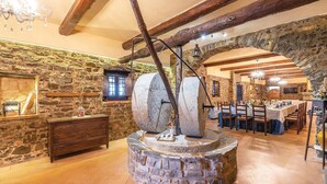 A rustic stone interior with a large stone mill, wooden furniture, and exposed beams. - Beautiful home in Stella Cilento with sauna (Stella Cilento)