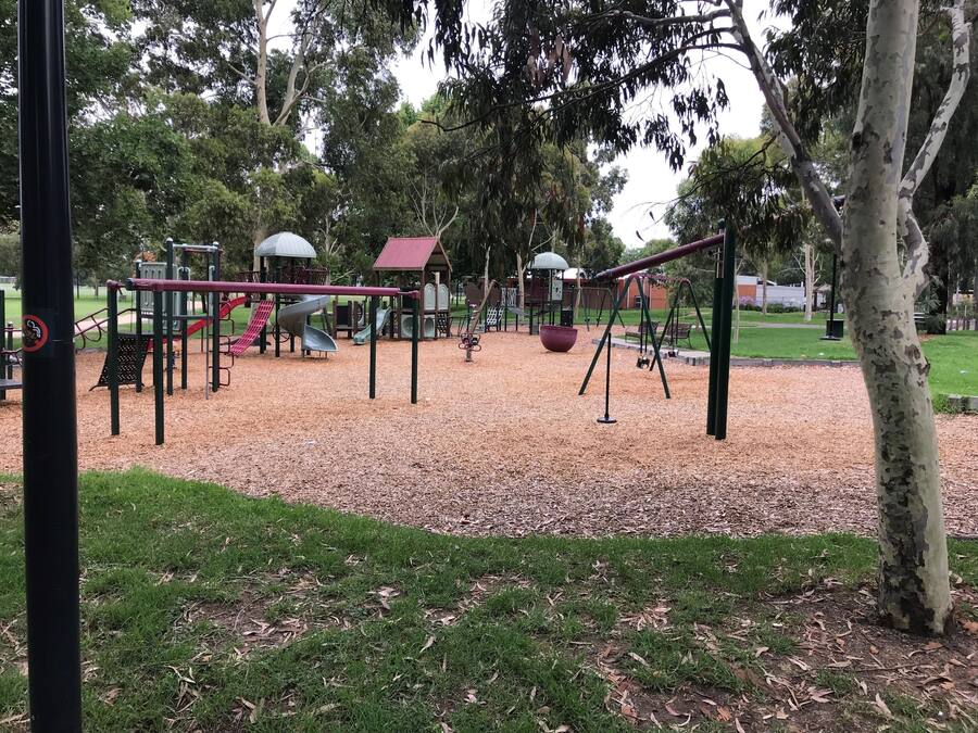 A playground with swings, slides, and a climbing structure.
