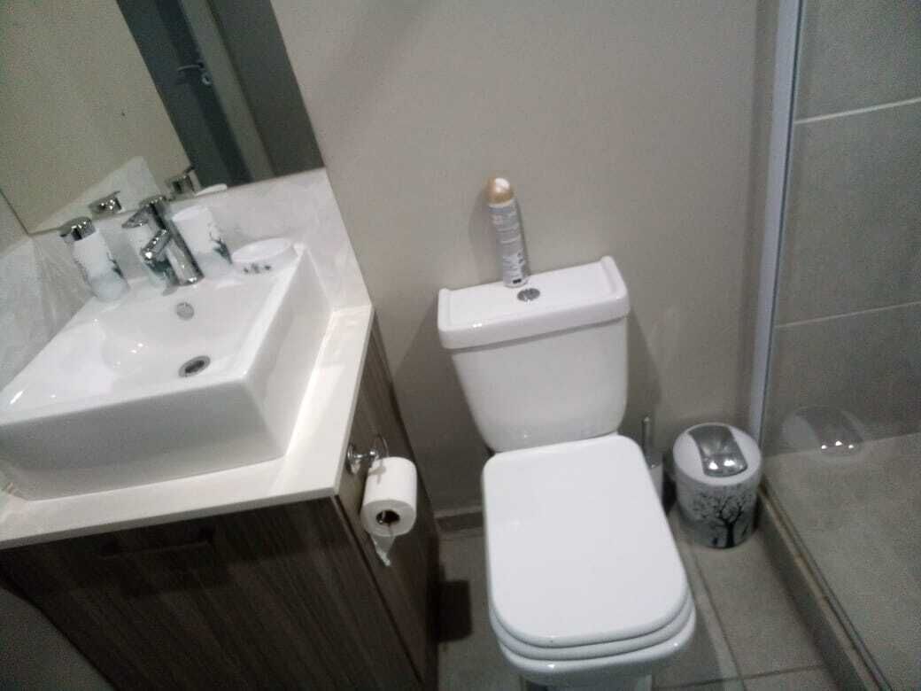 A bathroom with a white sink, toilet, and bidet.