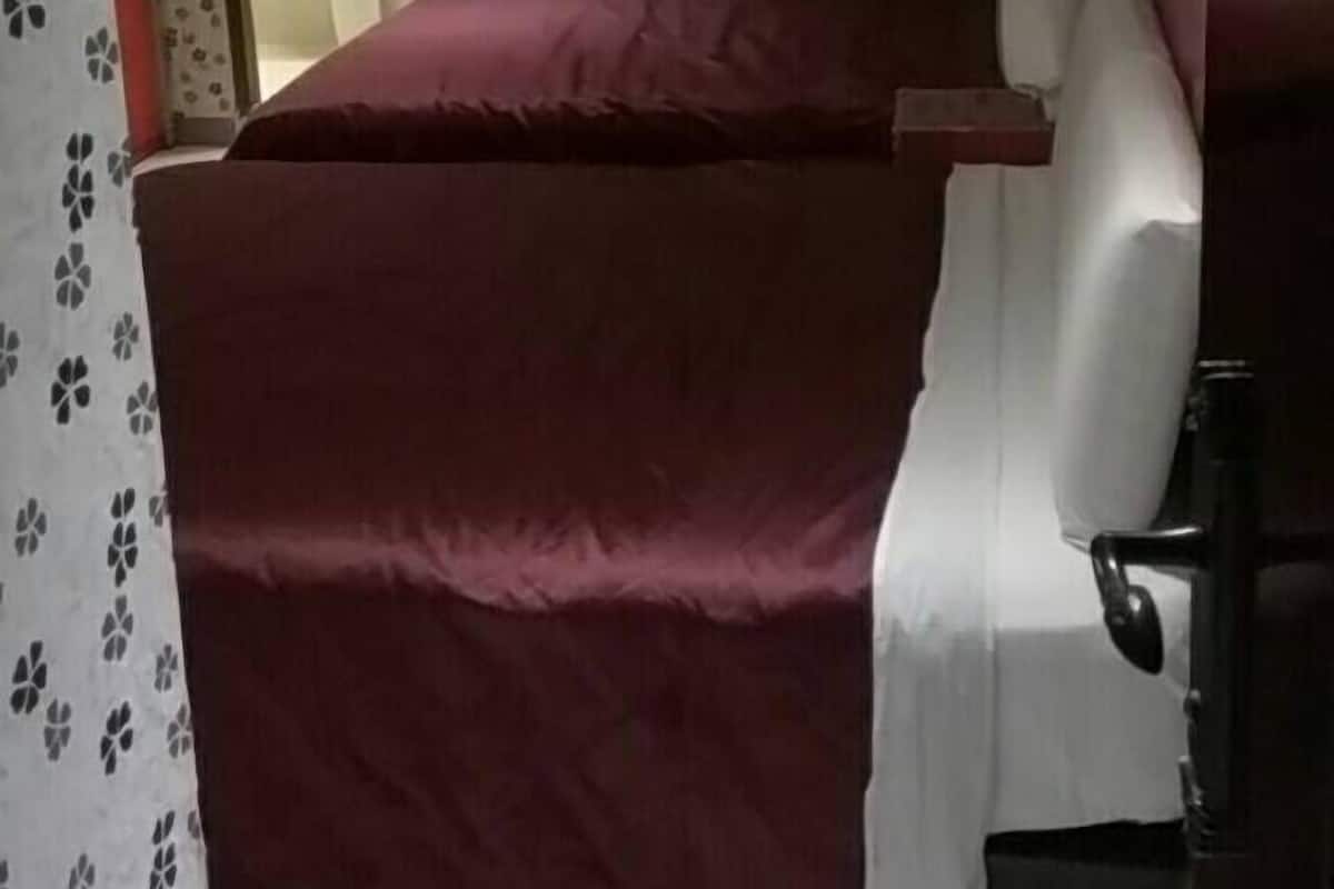 A bedroom with a large bed, a bedside table, and a bathroom visible through an open door.