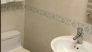 Een badkamer met toilet, wastafel en handdoekrek.