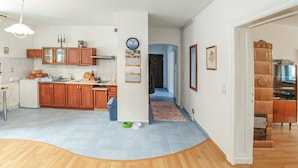 Una cocina amplia con armarios de madera, horno empotrado y comedor con mesa y sillas.