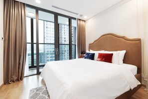 Une chambre d’hôtel avec un grand lit, une vue sur de hauts immeubles et une porte-fenêtre coulissante.