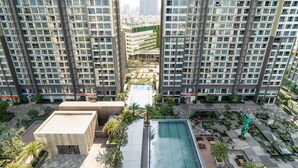 A high-rise residential building with multiple balconies, a rooftop pool, and surrounding greenery. - Hoasun Des Arts Landmark 81 (Ho Chi Minh City)