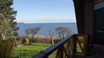 Um deck de madeira com vista para um corpo d'água e uma área terrestre distante.