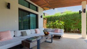 A modern outdoor seating area with two sofas, a coffee table, and a wooden ceiling. - Villa Oxavia (Rawai)