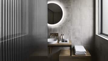 Un bagno moderno con uno specchio rotondo, un lavandino e un mobile bagno in legno.