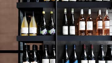 A wine rack with various bottles and glasses.