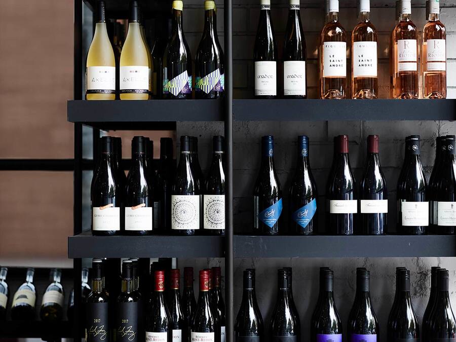 Una dispensa per vino con diverse bottiglie e bicchieri.