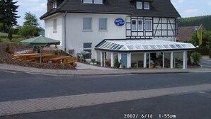 A two-story building with a sign indicating it is a hotel. - Hotel am Salzberg (Philippsthal)
