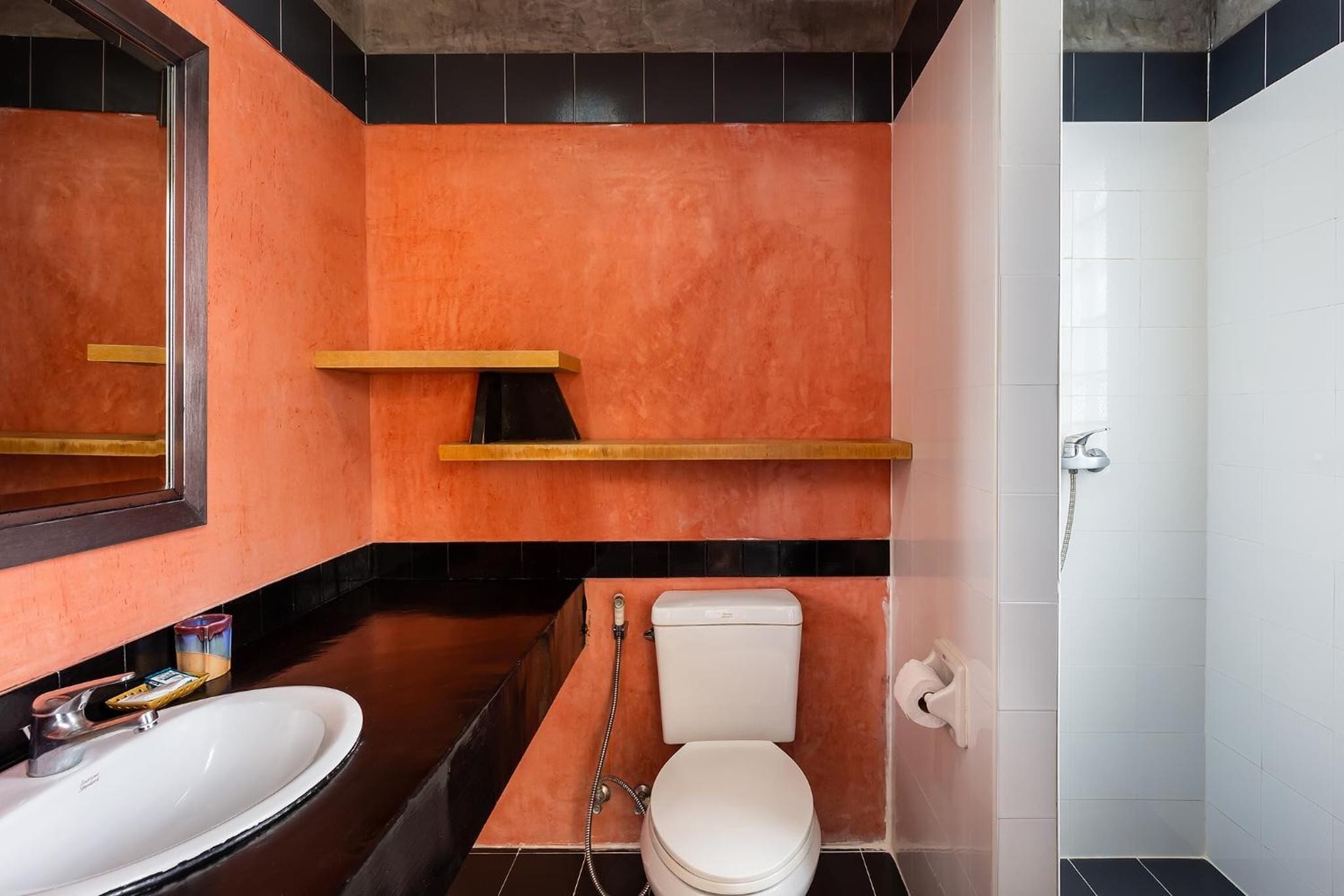 A bathroom with a white toilet, a sink, and a shower.