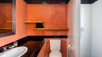 A bathroom with a white toilet, a sink, and a shower.
