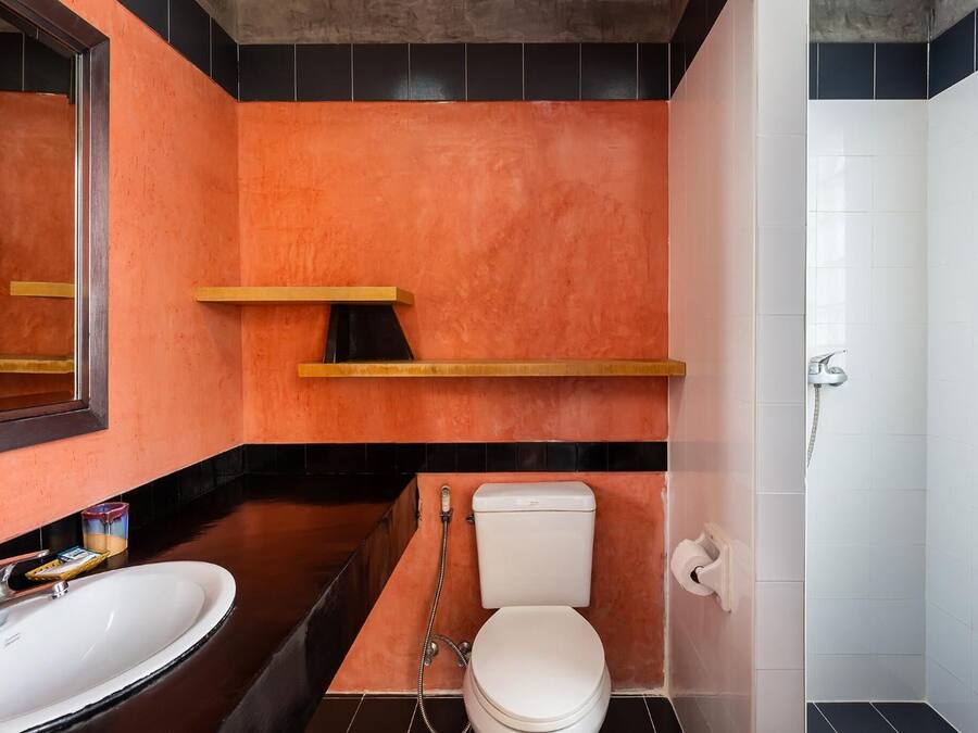 A bathroom with a white toilet, a sink, and a shower.