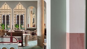 A spacious interior with a high ceiling, arched windows, and a seating area with a red cushioned chair. - Il Palazzo Experimental (Venice)