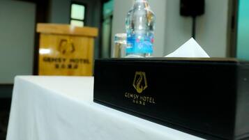 A black box with the GEMSY HOTEL logo on a white tablecloth.