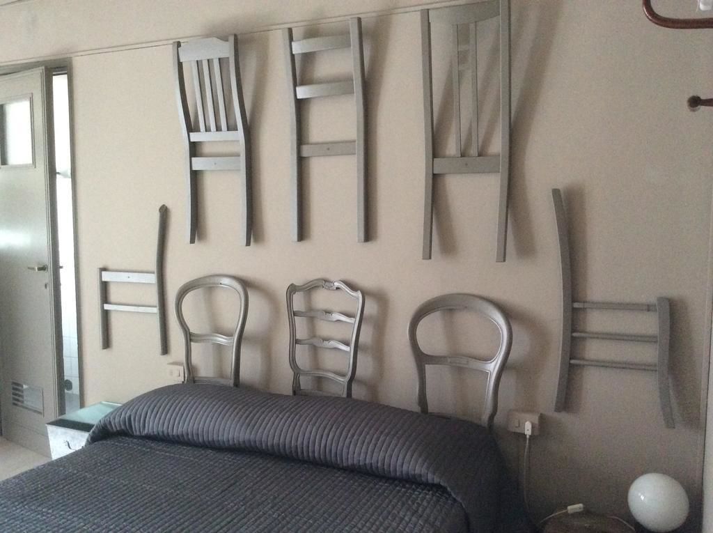 Een slaapkamer met een bed, een dressoir en een wandstoel.