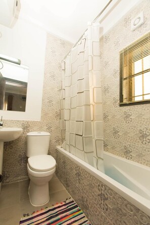 Bathtub besar, pancuran hujan,  dan handuk