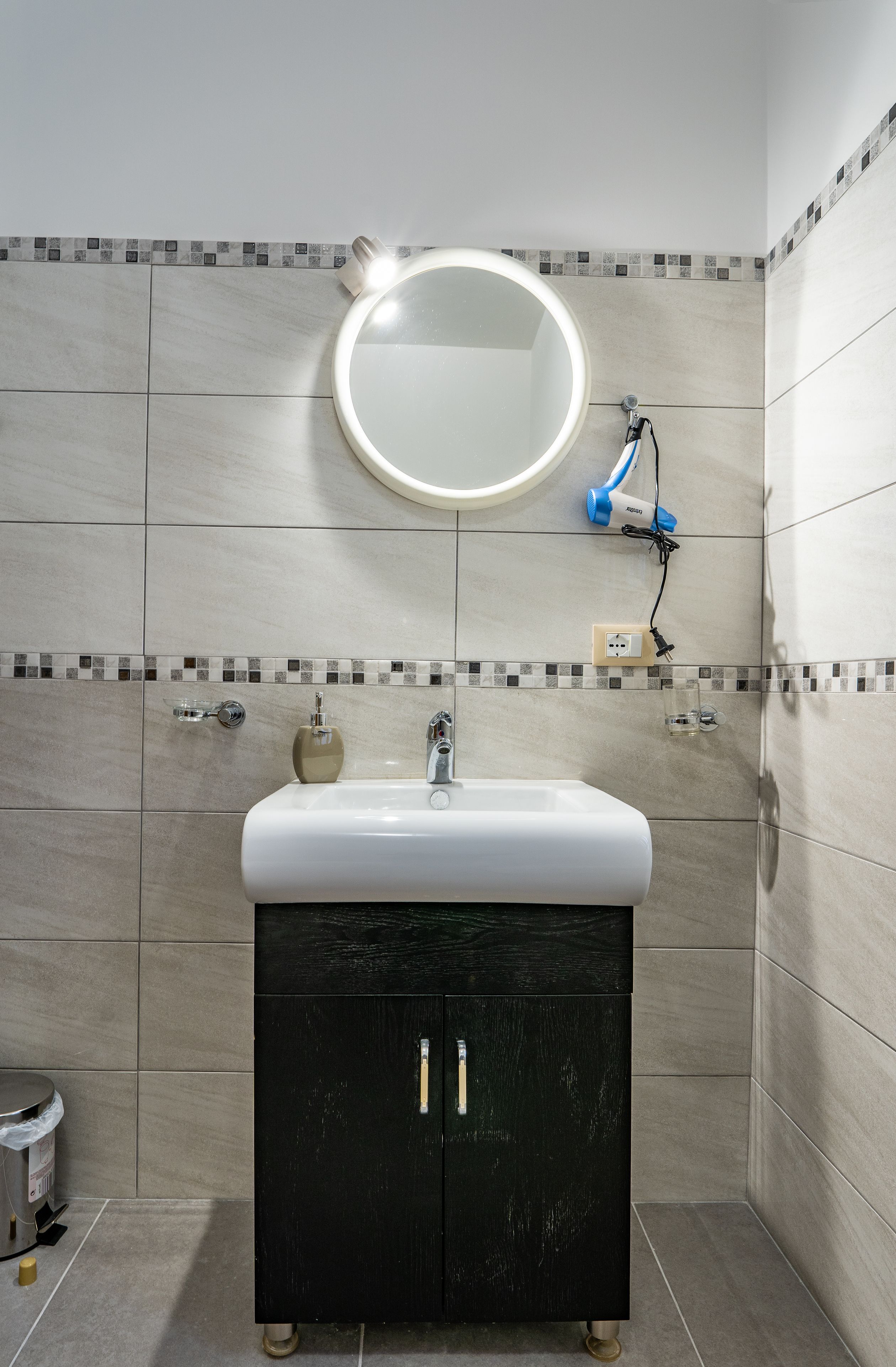 A bathroom with a sink, mirror, and cabinet.