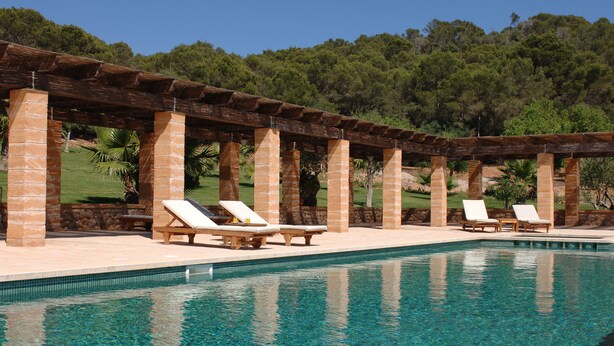 Una piscina al aire libre, sillones reclinables de piscina
