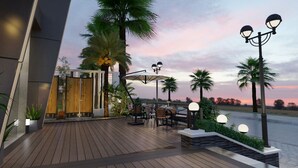 Une terrasse extérieure dotée d’un plancher en bois, de sièges et d’un éclairage d’ambiance.