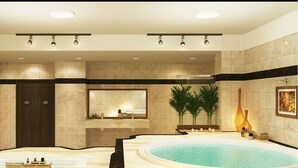 Une salle de bain luxueuse avec une grande baignoire, un miroir et un luminaire fixé au mur.