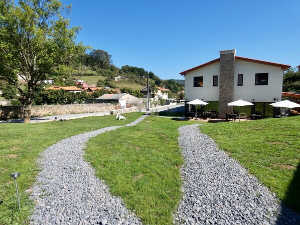 A building with outdoor seating and a gravel path leading to it. - Casa Sueño (Salas)