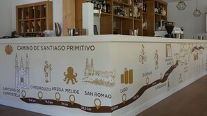 A reception area with a counter displaying a map of Camino de Santiago. - Casa Sueño (Salas)