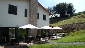 A building with outdoor seating and stone pillars. - Casa Sueño (Salas)