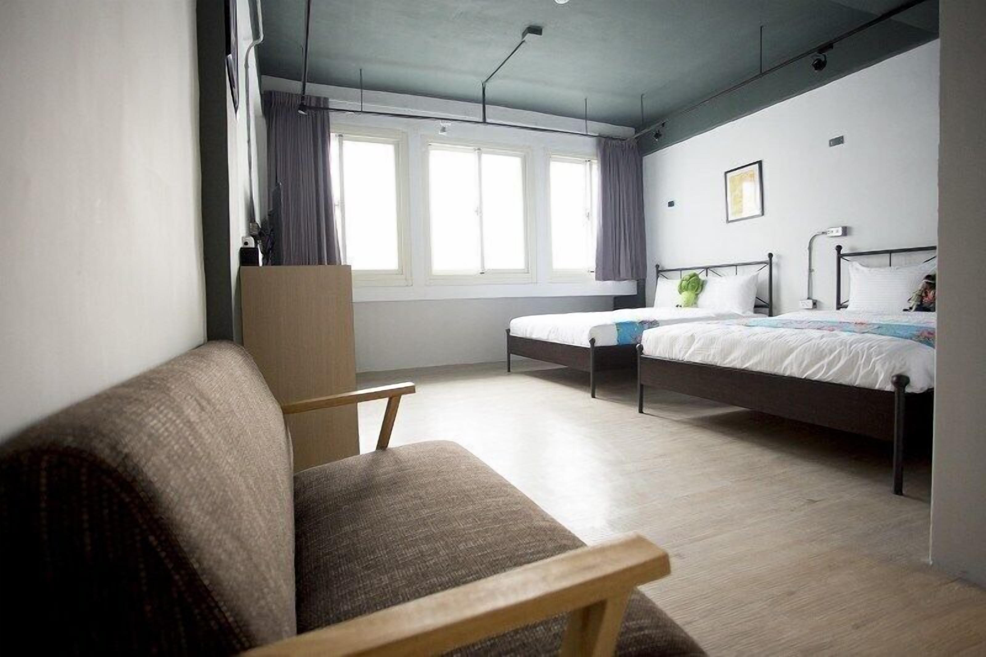 Una habitación de hotel moderna con una cama grande, una silla de madera y un escritorio.