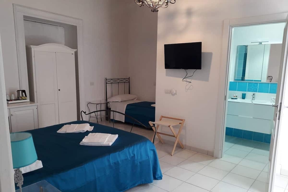 Un dormitorio con dos camas, un televisor, una mesita y una silla.
