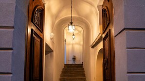 A grand staircase with a chandelier, flanked by wooden doors and walls. - Residenza d'Epoca Olimpia (Castellabate)