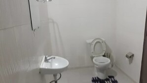 A bathroom with a white sink, toilet, and bidet. - Hotel Restaurant du 3ème Pont (Abidjan)
