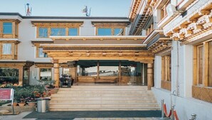 A building with a traditional architectural style, featuring a wooden facade and a covered entrance area. - Ladakh Himalayan Retreat (Leh)