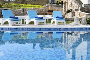 Una piscina al aire libre, sombrillas, tumbonas