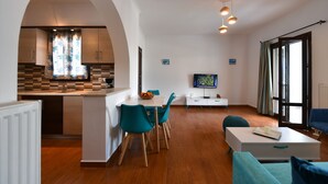 Un salon moderne comprenant un coin repas, une cuisine et un téléviseur.