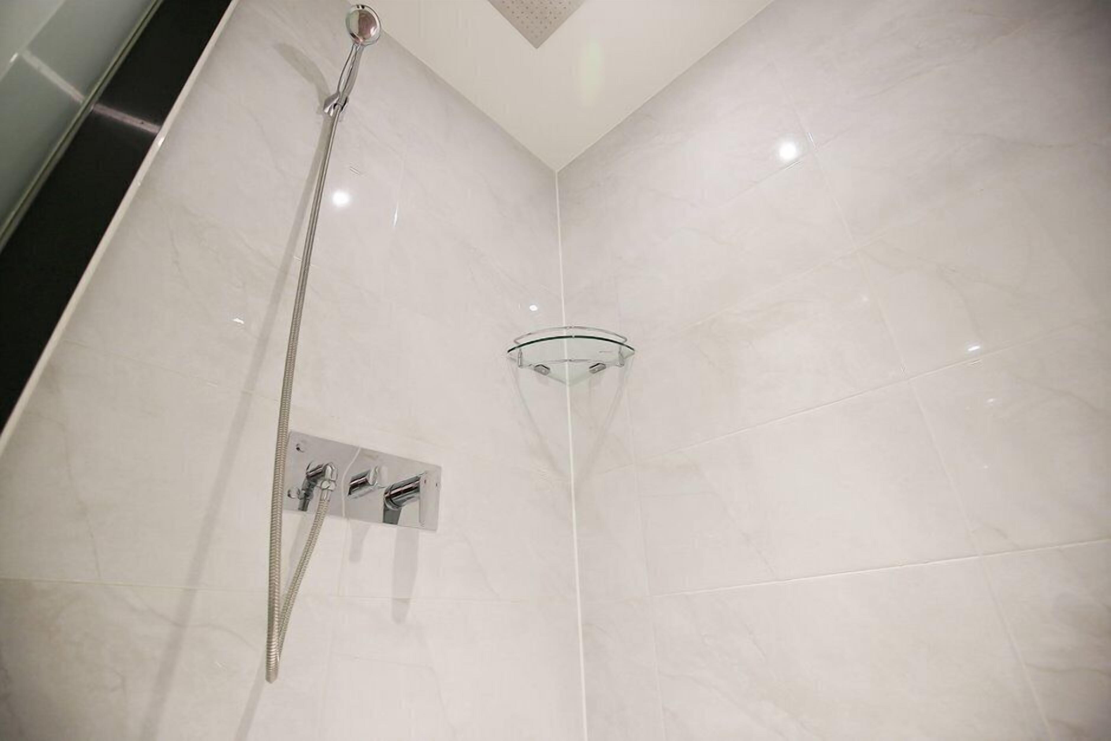 Eine moderne Dusche mit Glasabtrennung und Handbrause.