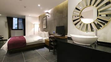 Relax in a stylish room with a neatly made bed, large mirror, and flat-screen TV.