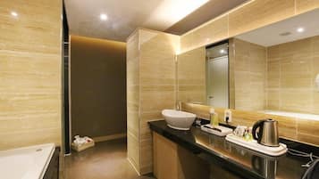 A modern bathroom with a large mirror, a white sink, and a black countertop.