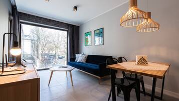 Sala de estar moderna com sofá, mesa de jantar e luminárias pendentes.