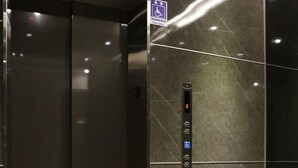 An elevator with a control panel, a wheelchair accessibility sign, and a textured floor. - Tag inn (Taoyuan City)