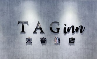 A wall with the text "TAGinn" and Chinese characters, indicating a hotel or establishment.