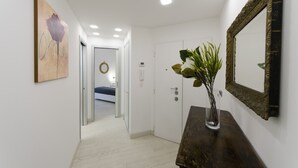 A hallway with a wooden console table, a mirror, and a painting. - JOIVY Nervi Charming Flat Santarosa (Genoa)