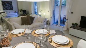 A dining area with a table set for four, including plates, cutlery, and glasses. - JOIVY Nervi Charming Flat Santarosa (Genoa)